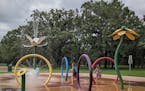 Plainville residents Sasha Fallon, 6, and Chelsea Fallon, 10, and St. Cloud resident Shay Fallon, 7, from left to right, play at the splash pad on Mon