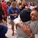 U.S. Olympic gold-medal gymnast Suni Lee hugged Mary Romoser, her grade school science teacher, during a back-to-school donation event Thursday with A