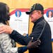 Nyamal Dei, a school board member in Fargo, N.D., is greeted by Vietnam veteran David Halcrow following a special meeting on Thursday, Aug. 18, 2022, 