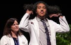 Medical student Chris Tadros adjusts his hair after Dr. Sheilagh Maguiness gave him his white coat during the University of Minnesota Medical School�