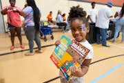 Skyler Thomas, 5, posed with books handed out by the Planting People Growing Justice Leadership Institute.