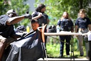 Leonard Young, with Next Level Barbershop, cuts the hair of Rashad Isaak, 5, of St. Paul, Tuesday, during the “Barbers and Backpacks” giveaway eve