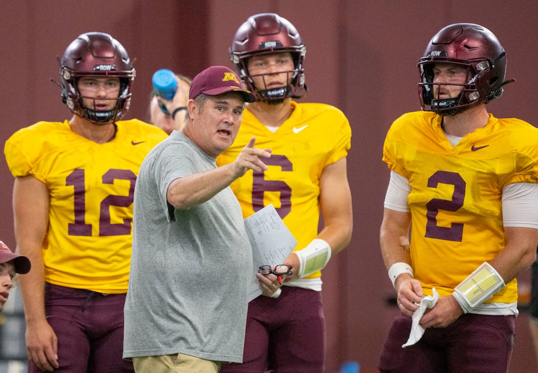 Gophers football offensive coordinator Kirk Ciarrocca spoke to quarterbacks Cole Kramer (12), Jacob Knuth (6) and Tanner Morgan (2) during a practice during training camp.
