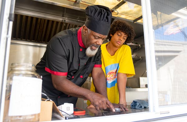 Ahman Laster shows his son Cash how to take orders and accept credit card payments for their Philly Ice Man food truck.