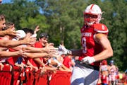 St. John’s tight end Alex Larson celebrated with students after scoring a touchdown in the team’s season opener.