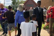 St. Paul Mayor Melvin Carter talked to neighbor Janis Jaja, who brought her two grandchildren with her to a news conference at the scene of Sunday’s