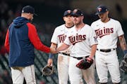 Minnesota Twins starting pitcher Dylan Bundy, second from right,, hands the ball to manager Rocco Baldelli, left, while being pulled from a baseball g