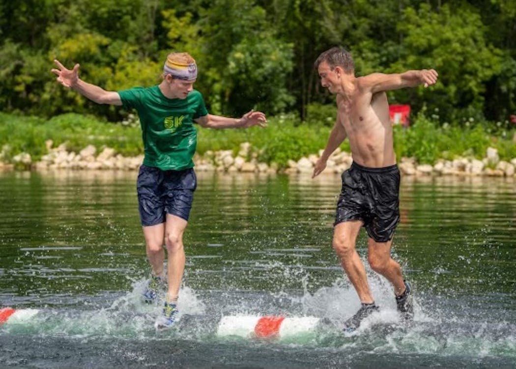 Jasper Priest, left, competing against Shane Burns in a log rolling competition in La Crosse. 