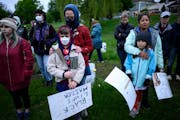 Community members bowed their heads during a vigil at the Say Their Names Cemetery on the second anniversary of George Floyd’s murder last May in Mi