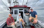 Pete Harris, left, of Grand Marais and Terry Arnesen and Mark Strelnieks of the Twin Cities are joined by Fetch, a yellow Labrador, on Arnesen’s boa