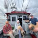 Pete Harris, left, of Grand Marais and Terry Arnesen and Mark Strelnieks of the Twin Cities are joined by Fetch, a yellow Labrador, on Arnesen’s boa