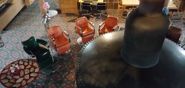 The lobby of the quirky Don Q Inn, located in Dodgeville, Wis., features a fireplace made from a steam engine surrounded by barbershop chair.