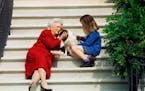 First Lady Barbara Bush, her granddaughter Barbara, and dog Millie waited on the steps of the White House for U.S. President George H.W. Bush in 1991.