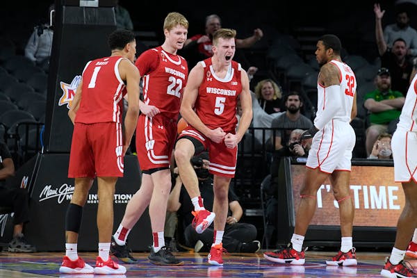 Lakeville North grad Tyler Wahl (No. 5) celebrated with Wisconsin teammates Johnny Davis (No. 1, from La Crosse, Wisc.) and forward Steven Crowl (No. 