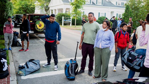 Migrants, who arrived on a flight sent by Florida Gov. Ron DeSantis, gather with their belongings outside St. Andrews Episcopal Church, on Sept. 14 in