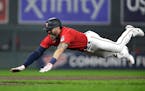 Jake Cave dives into third base on a triple against the Los Angeles Angels during the fourth inning Saturday