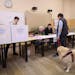 A voter with a dog arrives at a polling station in Bologna, Sunday, Sept. 25, 2022.