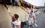 Gophers players, including Josh Aune (29) and John Michael Schmitz (60) celebrated with fans after their 34-7 win at Michigan State.