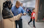 Gideon Pond Elementary social worker Abdullahi Khalif, right, consulted with a parent in her native Somali language Friday at the school in Burnsville