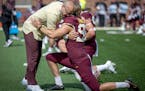 Gophers coach P.J. Fleck, shown here hugging punter Mark Crawford, is calling on fans, boosters, alumni and others to support Minnesota athletes via D