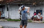 A man carries a sack with food in Batabano, Mayabeque province, Monday ahead of the arrival of Hurricane Ian. 