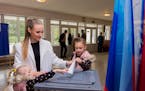 A woman voted with her children at a polling station in Luhansk, Luhansk People’s Republic controlled by Russia-backed separatists, Ukraine, Tuesday