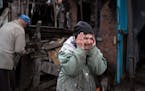 Valentina Bondarenko reacts as she stands with her husband Leonid outside their house that was heavily damaged after a Russian attack in Sloviansk, Uk