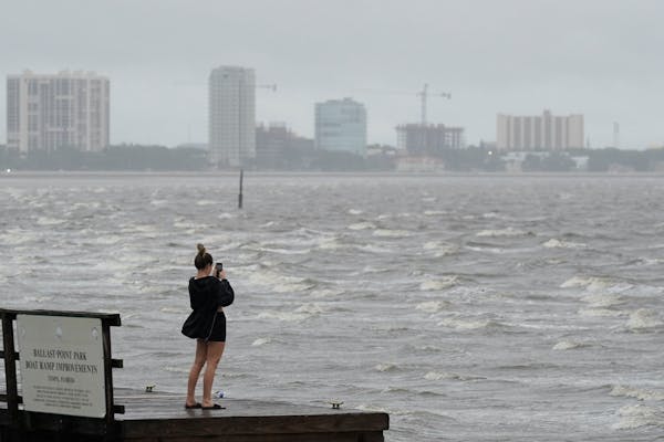 A woman took photos of the surf on Tampa Bay ahead of Hurricane Ian on Wednesday in Tampa, Fla. 