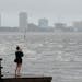 A woman took photos of the surf on Tampa Bay ahead of Hurricane Ian on Wednesday in Tampa, Fla.