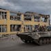 Ukrainian soldiers ride past a destroyed building in the town of Kupiansk, Ukraine, on Tuesday, Sept. 20, 2022. After stunning battlefield setbacks, R