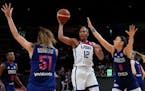 Alyssa Thomas passes the ball as Serbia’s Mina Dordevic, left, and Sasa Cado attempt to block during their quarterfinal game at the women’s Basket