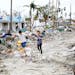 Jake Moses, 19, left, and Heather Jones, 18, of Fort Myers, explore a section of destroyed businesses at Fort Myers Beach, Fla., on Thursday after Hur