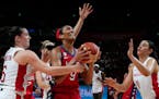 A’ja Wilson shoots as Minnesota Lynx players on the Canadian team — Bridget Carleton, left, and Natalie Achonwa, right — attempt to defend her.