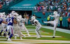 Miami Dolphins punter Thomas Morstead (4) sees the ball go backwards after attempting a punt during the second half of an NFL football game against th