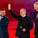 Russian President Vladimir Putin, center, waves as Denis Pushilin, leader of self-proclaimed of the Donetsk People’s Republic, left, and Moscow-appo