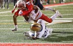 Robbinsdale Armstrong’s Reggie Carter jumped over Chanhassen’s Noah Kloke for a touchdown in the first quarter Friday.