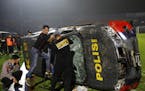 Officers examined a damaged police vehicle following a clash between supporters of two Indonesian soccer teams at Kanjuruhan Stadium in Malang, East J