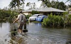 A resident walks back home on a flooded street following Hurricane Ian in Fort Myers, Florida, on Sept. 29, 2022. 