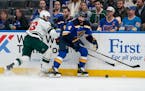 St. Louis Blues’ Nick Leddy chases after a loose puck along the boards as the Wild’s Sam Steel defends during the first period Tuesday