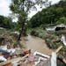 Debris from destroyed homes piled up near a concrete bridge over Grapevine Creek in Perry County after torrential rain caused flash flooding in Easter
