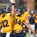 Beau Nelson (12) celebrated one of two touchdown passes he caught from Jonathan Singleton (14) in Carleton’s 56-27 victory over Macalester. Singleto
