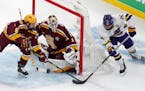 Minnesota State Mankato’s Ryan Sandelin, right, tried to tuck the puck past Gophers goalie Justen Close as Mike Koster defended during the 2022 NCAA