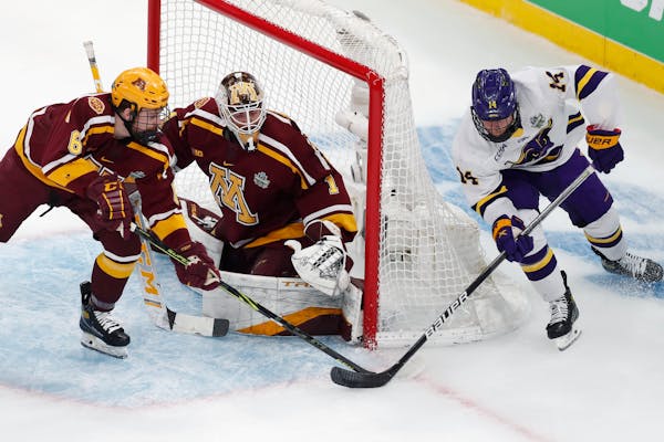 Minnesota State Mankato’s Ryan Sandelin, right, tried to tuck the puck past Gophers goalie Justen Close as Mike Koster defended during the 2022 NCAA