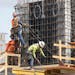 Construction workers fasten the frame of a new building in Miami. America’s employers slowed their hiring in September but still added a solid 263,0