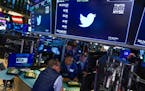 Traders gathered around a post as Twitter shares resumed trading at the New York Stock Exchange on Oct. 4, 2022, following news that Elon Musk was wil