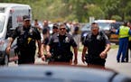 FILE — Police walk near Robb Elementary School following a shooting, May 24, 2022, in Uvalde, Texas. Four months after the Robb Elementary School sh