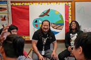 American Indian Magnet School teacher Thomas Draskovic, center, shares a light moment with seventh-grader Davion Williams, right, during practice with