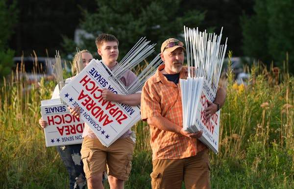 Campaign supporters carry signs for Senate candidate Andrea Zupancich to a rally with Republican governor candidate Scott Jensen.