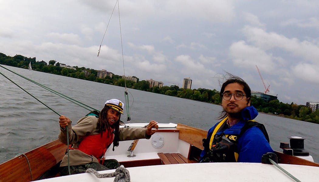 Chance York, left, at the tiller of a sailboat with Joseph Leadley, equity and inclusion coordinator of the Minneapolis Sailing Center.