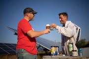 Previn Solberg, president and founder of Invictus Brewing Co., left, with a beer made with honey from the hives kept by Dustin Vanasse, owner of Bare 